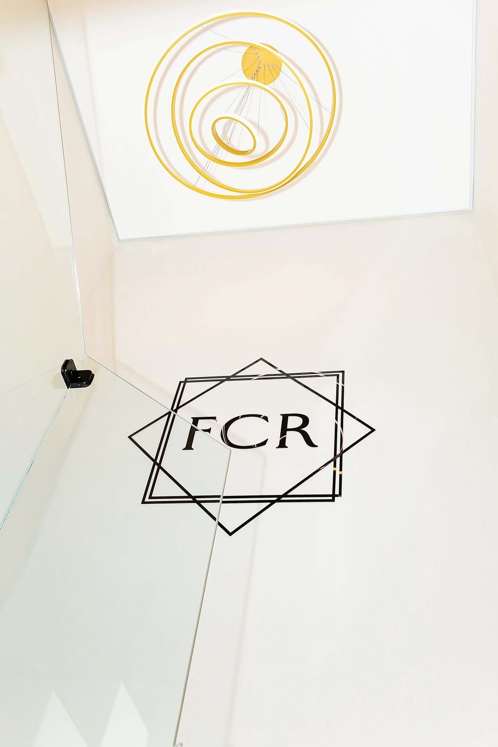 Detalhe da recepção do escritório FCR Advogados com a marca aplicada em vidro
